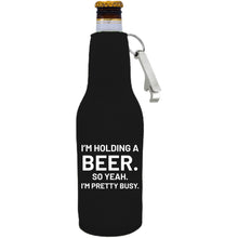 Load image into Gallery viewer, 12oz. neoprene beer bottle koozie with metal opener attached to the zipper, and "I'm holding a beer.." graphic printed on the opposite side.