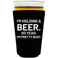 Load image into Gallery viewer, collapsible, neoprene 16oz. pint glass koozie with &quot;I&#39;m holding a beer..&quot; graphic printed on one side.
