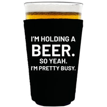 Load image into Gallery viewer, collapsible, neoprene 16oz. pint glass koozie with "I'm holding a beer.." graphic printed on one side.
