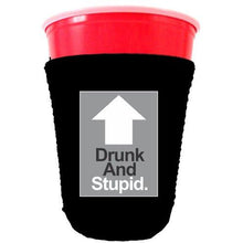 Load image into Gallery viewer, black party cup koozie with drunk and stupid design 
