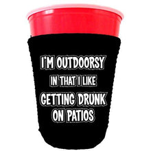 Load image into Gallery viewer, black party cup koozie with im outdoorsy in that i likle getting drunk on patios design 
