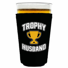 Load image into Gallery viewer, black pint glass koozie with trophy husband funny design
